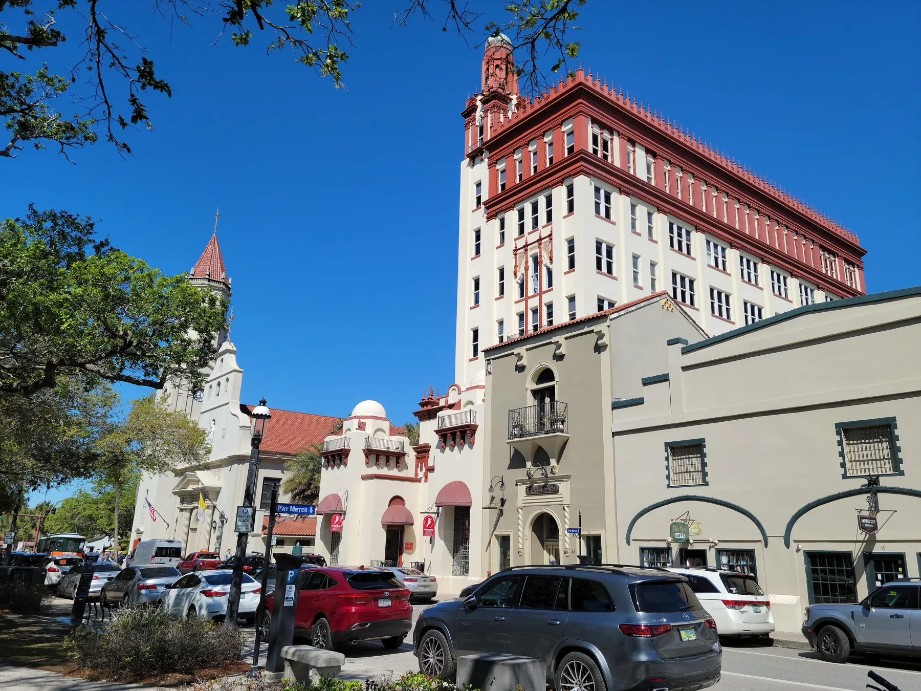 The Plaza de la Constitución in St. Augustine under a clear blue sky, with the Cathedral Basilica bell tower and the old Government House.